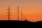 Towers of electricity over mountains at sunset