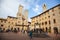 Towers and medieval well on Piazza della Cisterna in San Gimignano in tuscany in italy