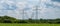 Towers with multiple power lines over a green field with blue sky