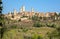 Towers and traditional brick houses of ancient Tuscan town at sunny day. Historic San Gimignano town. UNESCO Site