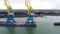 Towing cranes for containers. Large container ship pulled by tugboats. Top down aerial view. Container Cargo freight