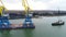 Towing cranes for containers. Large container ship pulled by tugboats. Top down aerial view. Container Cargo freight