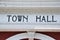 Town Hall spelled in black capital letters on white painted exterior of building