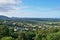 A town with houses surrounded by trees seen from Kuranda Scenic Railway train with ocean in the far end in Queensland, Australia