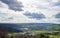 A town with roads, fields, pastures against the backdrop of silhouettes of hills and a cloudy sky