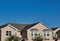 Townhome rooftops in the suburbs under a blue sky.