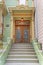 Townhouse entrance exterior with concrete doorsteps and large wooden double door