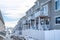 Townhouses on a snowy suburban neighborhood against cloudy blue sky in winter