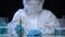 Toxic laboratory worker holding test tube with green ionizing radiation liquid