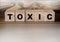 Toxic Word written on wooden cubes. Addiction concept