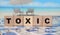 Toxic Word written on wooden cubes. Detox intoxication rehab stop smoking and drinking concept