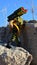 Toy action figure of GI Joe soldier named Backblast standing on coastal rocks with anti aircraft rocket launcher