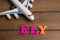 Toy airplane and the word fly made from colorful letters