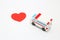 Toy ambulance car and abstract red heart on white background.