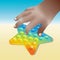 Toy antistress, Colorful rainbow Pop it fidget, kids sensory toy in hand. Play on the beach.