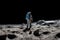 The toy of the astronaut stands on the moon\\\'s surface