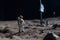 The toy of the astronaut stands on the moon\\\'s surface