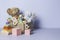 Toy box full of baby kid toys. Container with teddy bear, wooden rattles, stacking pyramid and wood blocks on light blue