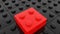 Toy brick in red on black toy bricks