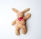 toy brown plush hare lies on a white background