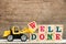 Toy bulldozer hold letter block w to complete word well done