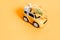 toy car bursts through torn paper, autumn on yellow paper. The concept of a cozy and modern autumn. Trend yellow background. Flat