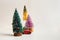 Toy car with chrstmas tree and three small colorful christmas trees