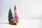 Toy car with chrstmas tree and three small colorful christmas trees