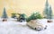 Toy cars in the forest among the snowdrifts, deliver Christmas trees. Blurred background. Magic atmosphere, concept of Christmas