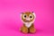 Toy cartoon lion king simba sits on a pink background
