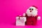 Toy cartoon santa with white gift boxes on a pink background
