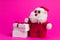 Toy cartoon santa with white gift boxes on a pink background