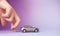 Toy child car in woman`s hand. Purchase insurance bank loan travel where to go trip journey concept. on violet