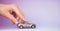 Toy child car in woman`s hand. Purchase insurance bank loan travel where to go trip journey concept. on violet