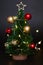 Toy christmas tree with balls on a black background with a garland. Cute