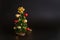 Toy christmas tree with balls on a black background with a garland. Cute