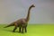 Toy dinosaur in a toy forest. like a real T-rex on a bright studio background with wooden trees. Eco toys.