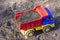 Toy dump truck stands on the ground full of sand