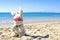 Toy Easter Bunny sits on the beach in glasses with on the sand