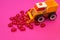 Toy excavator raking hearts. Pink background. Children`s love game