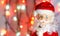 Toy, figurine, Santa Claus. Toy Santa Claus on the background of garland lights. Face, parts of the body of Santa Claus. New Year