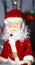 Toy, figurine, Santa Claus. Toy Santa Claus on the background of garland lights. Face, parts of the body of Santa Claus. New Year