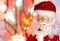 Toy, figurine, Santa Claus. Toy Santa Claus on the background of garland lights. Face, parts of the body of Santa Claus. New Year