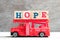 Toy fire ladder truck hold block in word hope on wood background