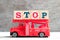 Toy fire ladder truck hold block in word stop on wood background