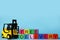 Toy forklift and cubes with words FREE DELIVERY on light blue background, space for text. Logistics and wholesale concept