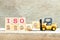 Toy forklift hold block 0 to complete word iso 22000 on wood background