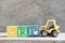 Toy forklift hold block P to complete word CRP abbreviation of C-Reactive Protein Test on wood background