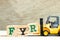 Toy forklift hold block R to complete word FYR abbreviation of for your reference on wood background