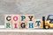 Toy forklift hold block t to complete word copyright on wood background